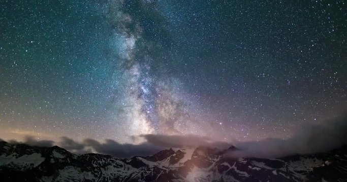 Milky way Time Lapse, starry sky rotating over the Alps in summertime. Motion clouds.