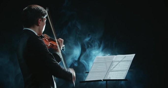 Asian violinist soloist male performing at a concert of classical music