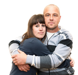 Young Caucasian couple embracing on white isolated background, looking at camera