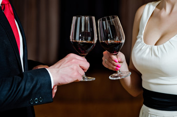 couple clink glasses with red wine at meeting or wedding
