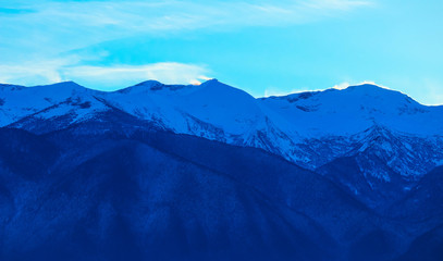 Mountain snow peak, beautiful natural winter backdrop. Ice top of the hill, blue sky background. Alpine landscape.