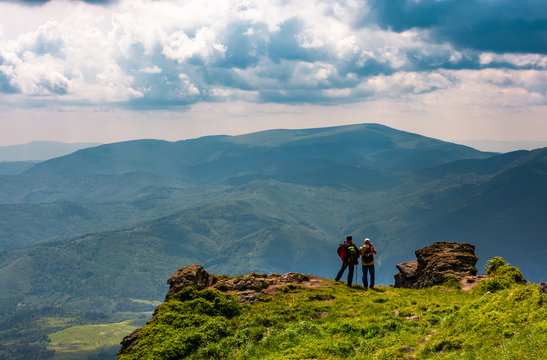 tourists stand on cliff enjoying the view. gorgeous view of magnificent Polonina Runa ridge from the hills of Pikui mountain. Location Ukrainian Carpathians