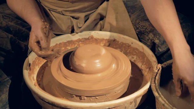 A potter adds moisture when throwing on a wheel.  