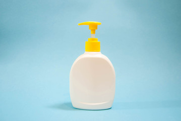Fototapeta na wymiar white soap bottle with dispenser on a blue background for mockup