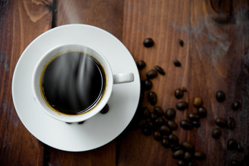 Hot coffee in white cup on wood background