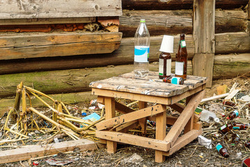 Abandoned house, a stool, empty bottles and glasses; desolation and autumn