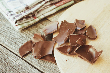 Crushed dark chocolate on old wooden table