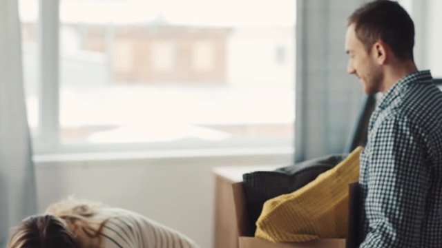 Young happy people entering new apartment. Very pleased Spaniel rejoicing return of hosts. Guy and girl stroking thoroughbred dog.