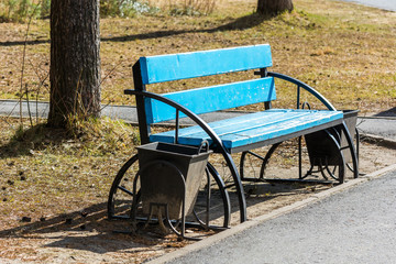 Blue bench with trash receptacle in the Park