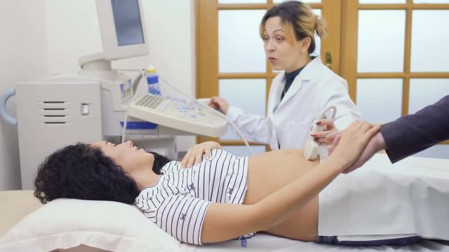 Doctor checks pregnant woman with ultrasound