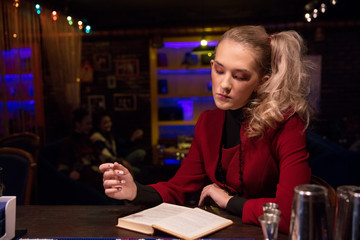 business girl in 90s style suit at  bar with  book