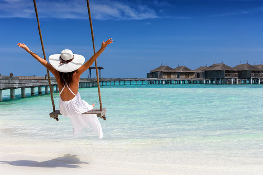 Attraktive Frau im weißen Kleid genießt ihren Sommerurlaub am tropischen Strand der Malediven