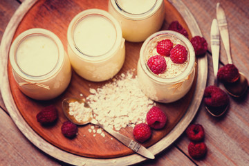 Jars with yogurt, raspberries and oat flakes 