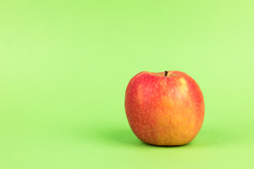 red apple on green background with copy space