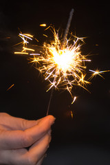 burning night sparklers in the hand of the girl
