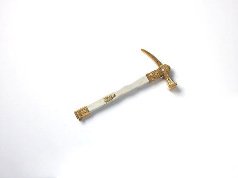 Antique gold and silver colour pickaxe, white background 