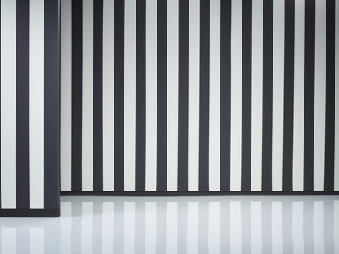 Black and white striped walls and reflective floor 