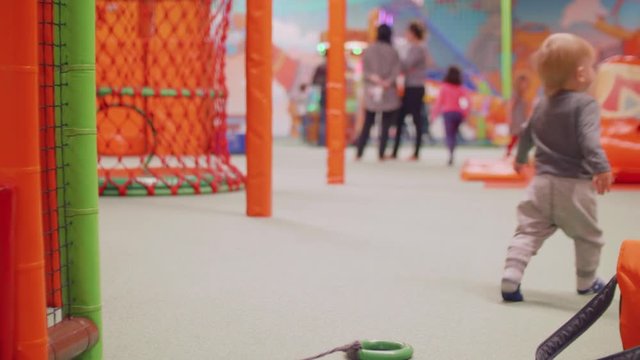 Blond toddler doesn't manage to dag tube and walks away