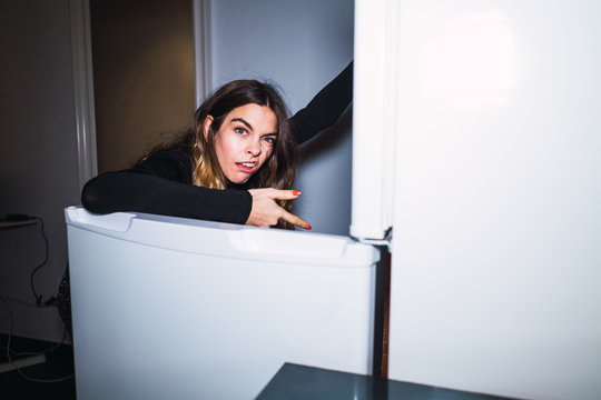 Disgusted woman at opened fridge