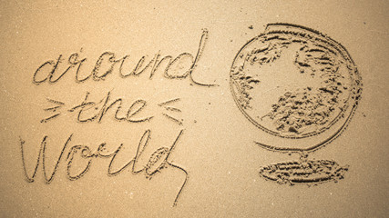 Around the World word is written on the beach sand