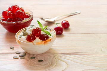 A bowl of greek yogurt with sugared cherry fruits, copy space.