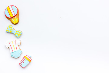 Bith of child concept. Cookies in shape of baby cloth and baby bottle on white background top view copy space