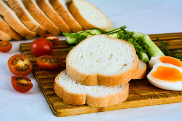 Breakfast of eggs, tomato, cucumber and bread