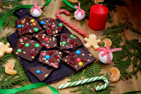Dark chocolate bark with multicoloured drops, nuts and dried fruits broken into pieces