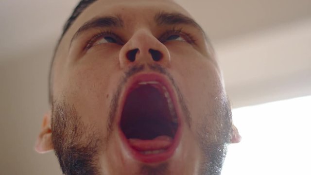 Young hispanic man making funny faces to camera and laughing