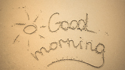 Good Morning word is written on the beach sand