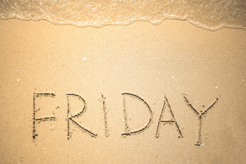 Friday word is written on the beach sand