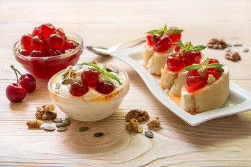 A bowl of greek yogurt and sandwiches with sugared cherry fruits.