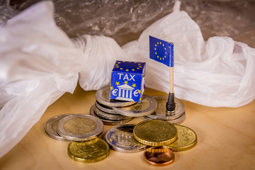 EU map with euro coins and a plastic bag symbolizing european plastic tax regulation.