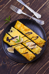 Home-made pancakes  filled with sweet white cheese, served with bananas, chocolate and mint. Wrapped pancakes. overhead, above, top view