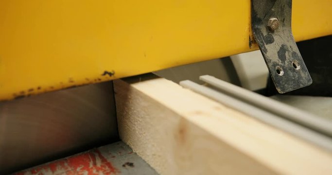 Close up of cutting wood by a big machine at the woodfactory. Furniture producing
