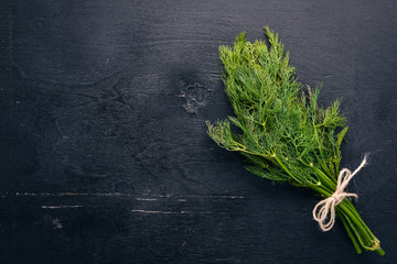 Fresh green dill on a wooden background. Top view. Free space for your text.