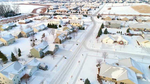 Beautiful neighborhoods in the grip of Winter, homes frozen under snow and ice, aerial view.