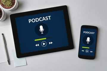 Podcast concept on tablet and smartphone screen over gray table. All screen content is designed by me. Flat lay