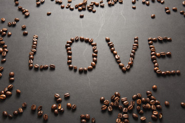 Top view of letter love, word made from coffee beans on black background for design. Saint Valentine's Day card on fabruary 14, holiday concept. Copy space for advertisement.