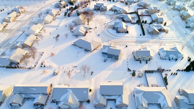 Beautiful neighborhoods in the grip of Winter, homes frozen under snow and ice, aerial view.