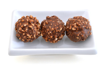 Chocolate candies isolated in white plate on white background cutout