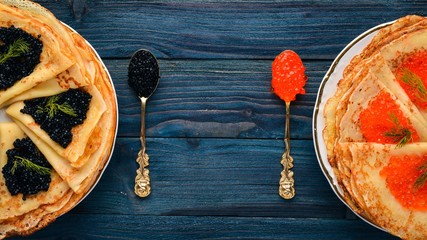 Pancakes with caviar. On a wooden background. Top view. Free space for text.