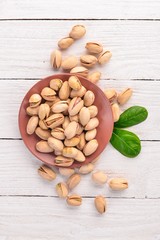 Pistachios nuts on a white wooden background. Healthy snacks. Top view. Free space for text.