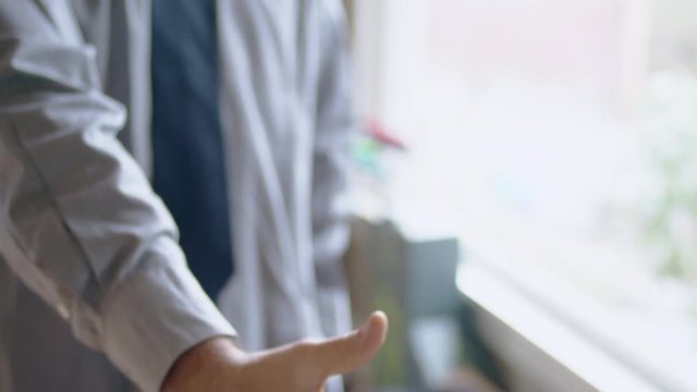 Young hispanic man practicing handshake in front of mirror