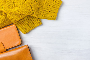 Elegant Stylish Female Women Accessories Yellow Leather Wallet Knitted Sweater Smartphone Case in Flat Lay Composition on White Wood Background. Fall Autumn Luxury Fashion Sale. Top View