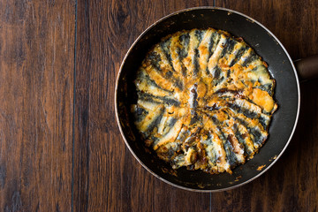 Fresh Fried Sardines in Pan on Wooden Surface.