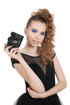 Young beautiful girl with makeup and haircut with a camera in her hand isolated on white background. Studio photography.