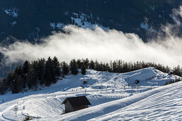Fototapeta na wymiar Wooden alpine hut in ski resort Serfaus Fiss Ladis in Austria with snowy mountains
