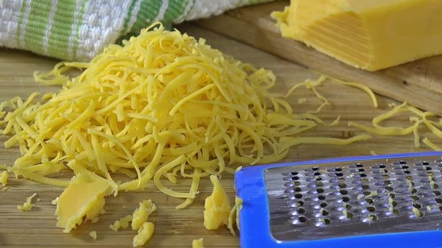 Slide shot across grated cheddar cheese