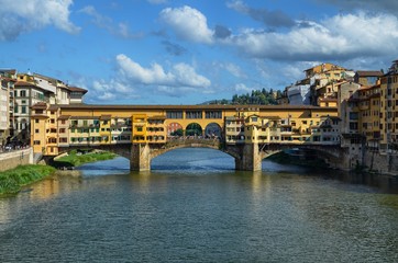 Fototapeta premium Florence, Pontevecchio, Tuscany, Italy August 27, 2014 Arno river. Blue sky with soft white summer clouds.